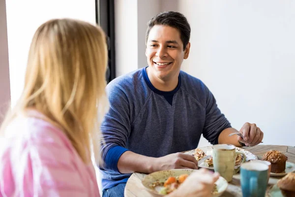 英俊年轻的西班牙裔男子看着他的女朋友 而在餐厅吃早餐 — 图库照片