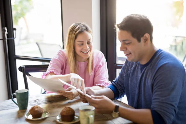 一对快乐的年轻夫妇的肖像阅读菜单卡和决定什么时候在餐厅闲逛 — 图库照片