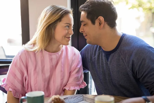 ハンサムな若い男にキスするカップルのカフェで彼の美しい恋人といちゃつく — ストック写真