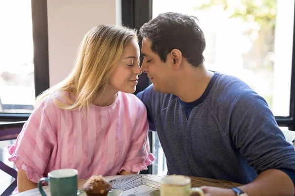 浪漫的拉美裔年轻夫妇即将在餐厅接吻 — 图库照片