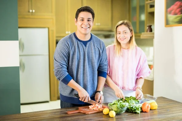 幸福的年轻夫妇在厨房里切新鲜蔬菜做健康沙拉的肖像 — 图库照片