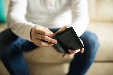 Onun cüzdanından para yaptırmayı kanepede oturan genç adam, yakın çekim