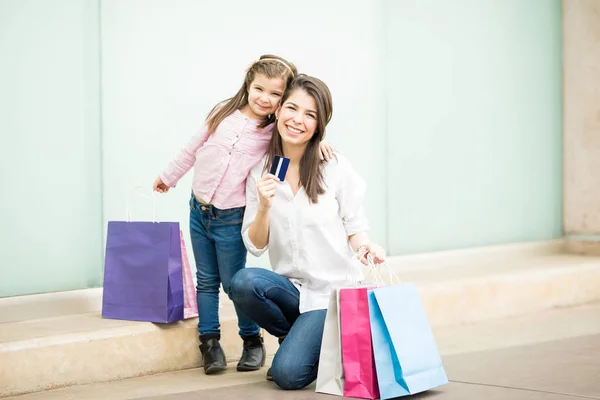 カラフルなショッピング バッグと表示クレジット カードの店の近くの娘と母 — ストック写真