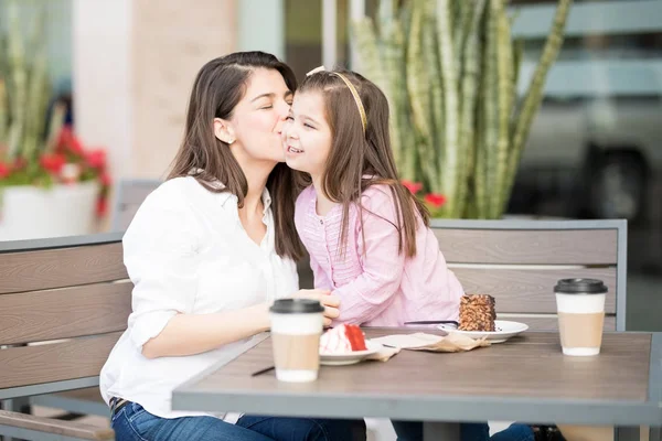 Mãe Beijando Filha Bochecha Café Fundo Borrado — Fotografia de Stock