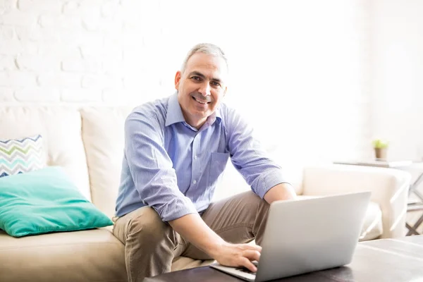 Pria Latin Yang Tampan Duduk Sofa Sambil Mengerjakan Laptop Dan — Stok Foto
