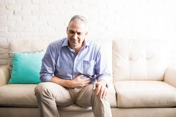 Viejo Sintiéndose Mal Con Dolor Estómago Mientras Está Sentado Sofá —  Fotos de Stock
