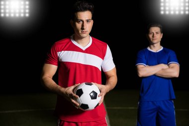 Topu rakip takım oyuncusu konumu olan arkada sahada tutan genç futbolcu portresi