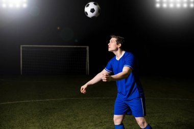 Futbolcu mavi üniformalı bir futbol spor alanında başlık 