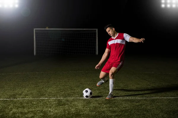 适合年轻的足球运动员踢足球在球场上的绿色球在比赛中 — 图库照片
