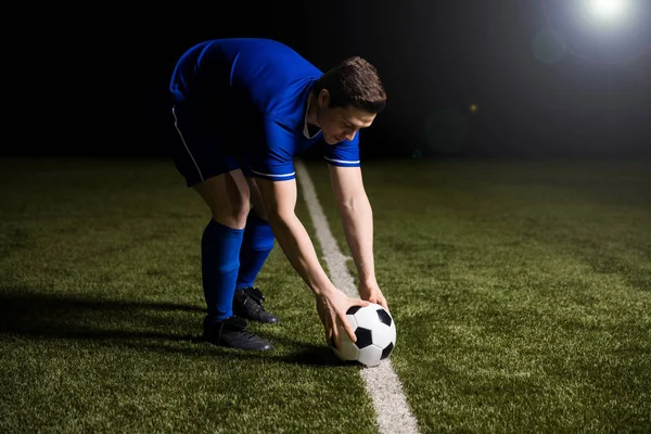 足球运动员在比赛中将球放在中场线上 — 图库照片