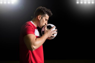 Profil görünümü genç İspanyol futbolcu kutlamak kazanan Stadı nda futbol topu öperek