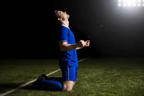 Happy young soccer player celebrates after scoring a goal during match in stadium