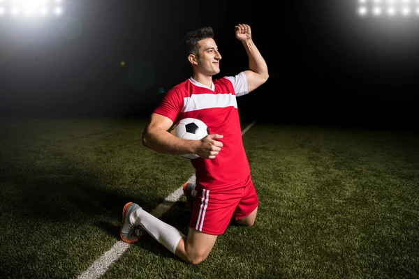 Jogador Futebol Masculino Segurando Uma Bola Futebol Levantando Braço Comemorando — Fotografia de Stock