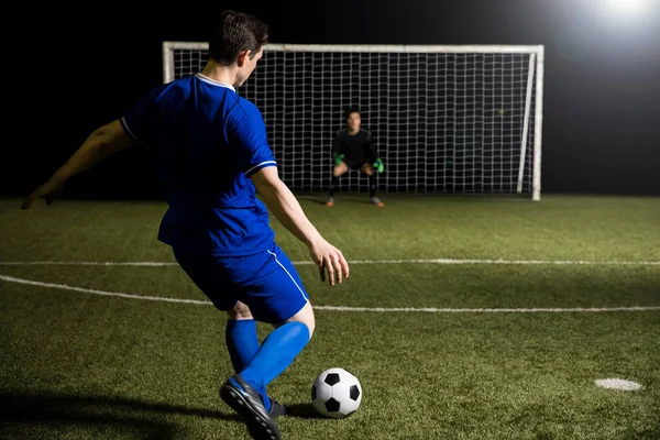 年轻的足球运动员采取点球踢对一个模糊的守门员在球门 — 图库照片