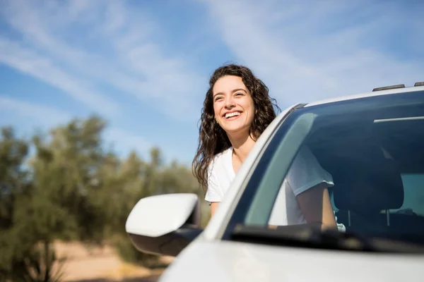ウィンドウを探して道の頭に車の助手席に若い女性を笑顔 — ストック写真