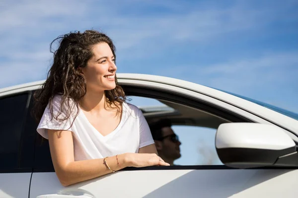 路上で車の窓から頭を探している若い女性の肖像画 — ストック写真