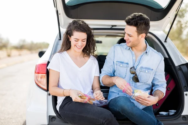 Paar Zitten Samen Kofferbak Van Auto Eten Sandwich Tijdens Reis — Stockfoto