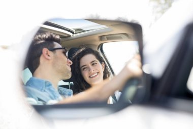 Mutlu genç adam ve birbirine bakarak ve gülümseyen kadın kanat ayna yansıması 