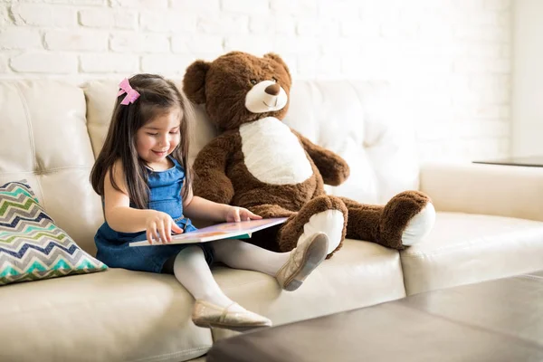 Ragazza Sorridente Seduta Sul Divano Leggere Libro Fiabe Con Orsacchiotto — Foto Stock