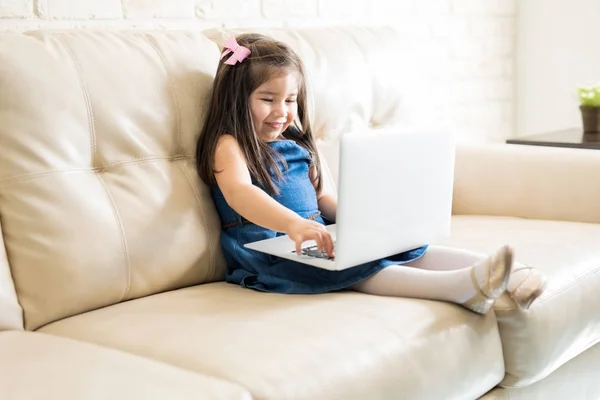 Niña Sentada Sofá Con Ordenador Portátil Sala Estar Casa — Foto de Stock