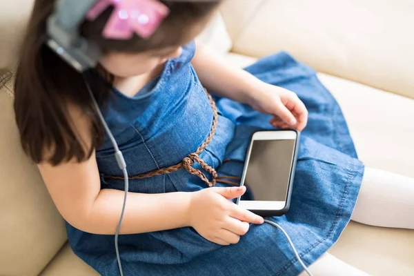 Dziewczyna Siedzi Kanapie Oglądać Film Animowany Smartphone Rezygnować Słuchawki Widok — Zdjęcie stockowe