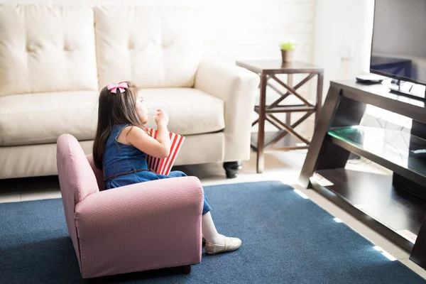 Menina Sentada Poltrona Comer Pipocas Assistir Filme Televisão Casa — Fotografia de Stock