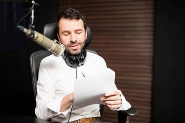 Radyo istasyonu mikrofon ve kulaklık ile genç erkek radyo ev sahibi portresi
