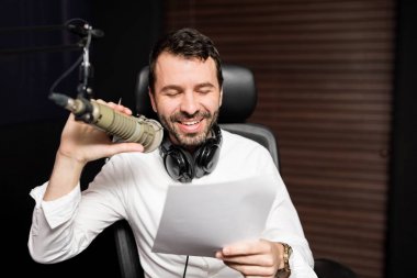 Radyo istasyonu mikrofon ve kulaklık ile genç erkek radyo ev sahibi portresi