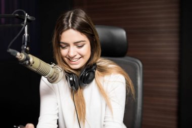 Genç kadın radyo host radyo istasyonu mikrofon ve kulaklık ile portresi