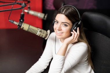 Genç kadın radyo host radyo istasyonu mikrofon ve kulaklık ile portresi
