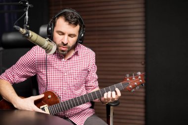 gitar çalmak ve radyo istasyonu mikrofon şarkı genç erkek şarkıcı