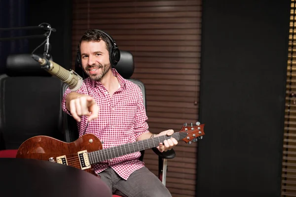 ラジオ局でギターを弾きながらラテン男の人差し指 — ストック写真