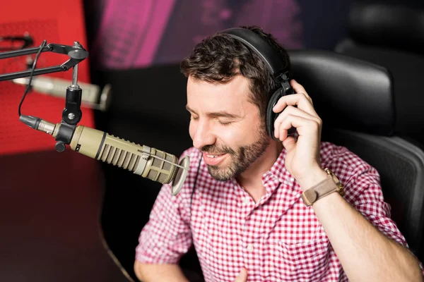 用耳机和麦克风在广播电台的年轻男性无线电主持人的肖像 — 图库照片