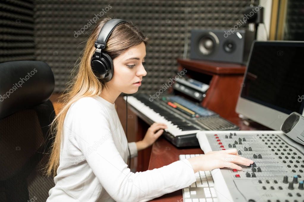 Female sound technician working on sound mixer console 