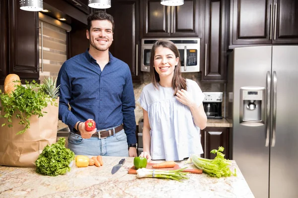 Feliz Casal Jovem Cozinha Com Saco Supermercado Legumes Tábua Cortar — Fotografia de Stock