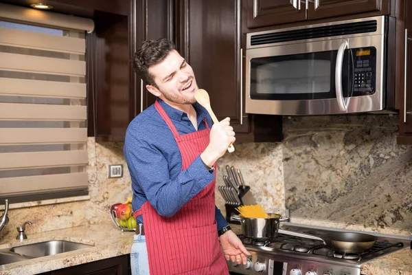 Pohledný Mladý Muž Hispánského Původu Zástěře Zpěvu Kuchyni Při Vaření — Stock fotografie