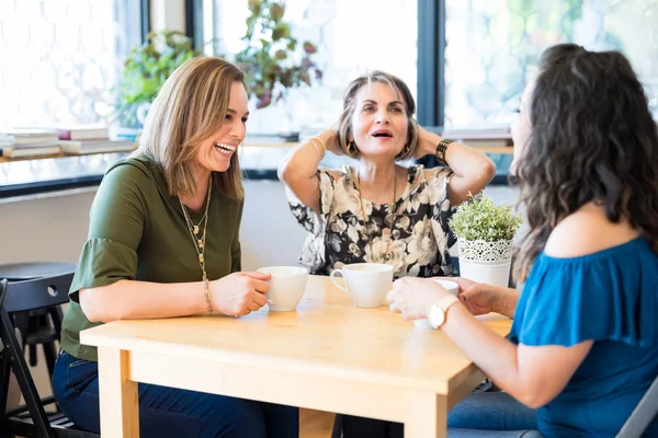 微笑的女性朋友在咖啡馆里放松 在喝咖啡的时候聊天 — 图库照片