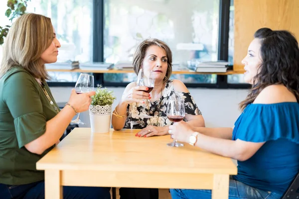 レストランでワインを飲みながら最新のゴシップ話ヒスパニックの女性の美しいグループ — ストック写真