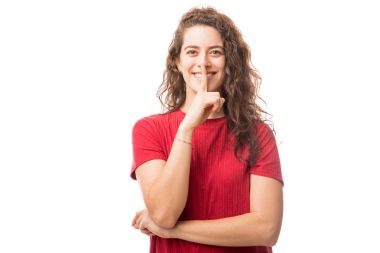 Beyaz arka plan üzerinde izole söylentiler yaymak değil gösteren dudaklarında parmak ile genç ve güzel esmer