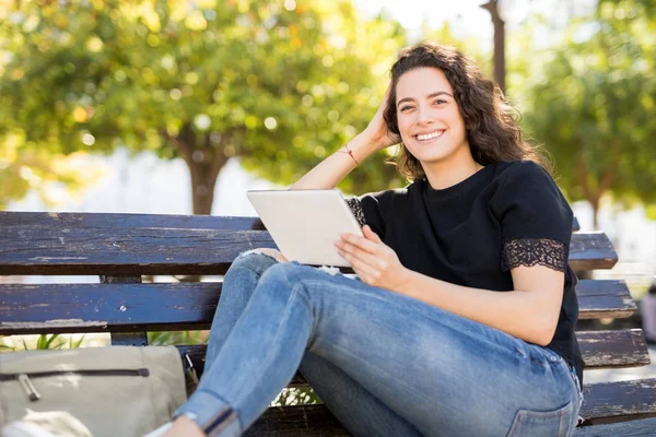 Schöne Junge Frau Sitzt Auf Einer Parkbank Mit Einem Tablet — Stockfoto