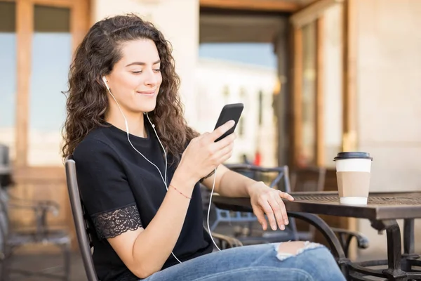 Ung Kvinna Sitter Café Bläddrar Music Spellista Sin Smarta Telefon — Stockfoto