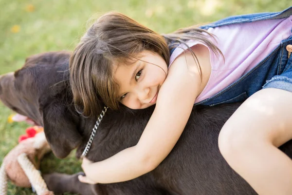 ペットの犬を受け入れる庭に座っているぽっちゃり少女の肖像画 — ストック写真