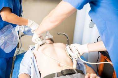 Acil sağlık ekibi hastane ciddi bir erkek hastada kalp masajı defibrilatör ile performans Close-Up