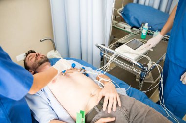 El makine tarafından ayakta hemşire ile hasta göğsüne EKG Elektrotları yerleştirerek hekimlerin