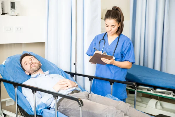 Hermosa Joven Doctora Escribiendo Una Prescripción Médica Para Paciente Masculino — Foto de Stock