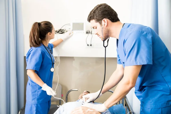 Equipe Médicos Verificando Batimentos Cardíacos Paciente Sala Emergência — Fotografia de Stock