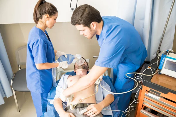 医院急诊室用除颤器进行心肺复苏的几个医生 — 图库照片