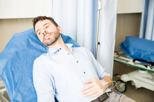 彼の手に点滴を病院のベッドの上に横たわる男性患者 — ストック写真