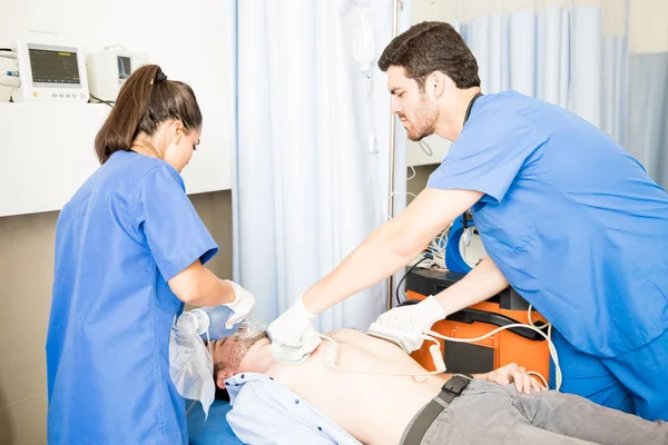 意識不明の男性患者に 除細動器と心臓マッサージを行う緊急医療チーム ストックフォト