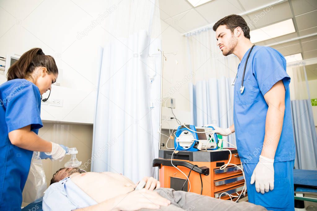 doctors using an ambu bag for ventilation to unconscious patient